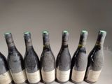six bottles of wine are lined up in a row on a table