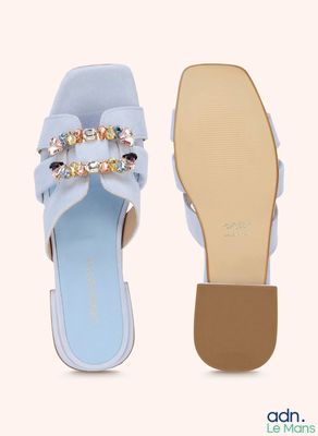 a close up of a pair of blue sandals with bows on them