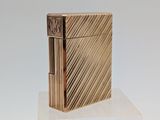 un briquet doré posé sur un bloc de verre transparent