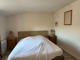 a large bed in the corner of a room with a large window