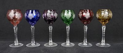 six verres à vin de couleurs différentes sont alignés