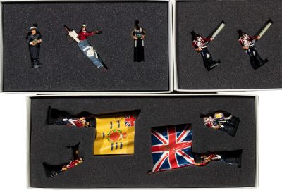 four miniature figurines of soldiers in a box
