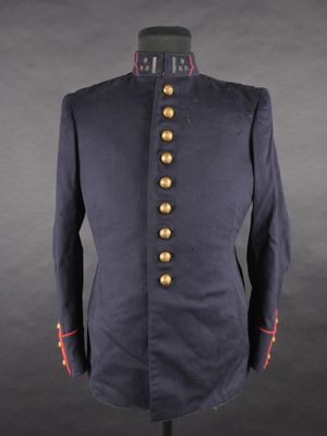 une veste militaire bleue à boutons dorés, posée sur un mannequin