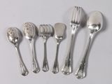 five silver spoons and a fork on a white surface