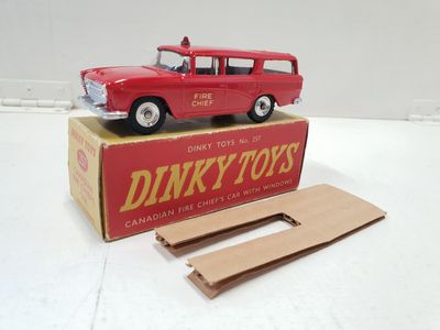 une petite voiture rouge posée sur une boîte en carton