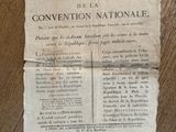 un vieux journal posé par terre, sur lequel se trouve un bout de papier