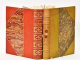 two books are stacked on top of each other on a white surface