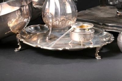 un plateau en argent sur lequel sont posés une théière et une tasse en argent