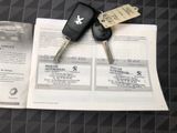 two keys on a piece of paper next to a pair of car keys