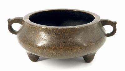 a small brown pot with handles on a white surface