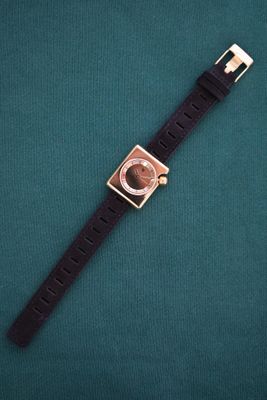 a watch that is laying on a green surface