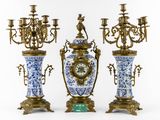three blue and white vases with a clock on them