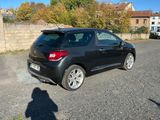 une petite voiture noire garée sur le bord de la route