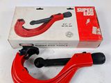 une photo d'un coupe-tube rouge posé sur une boîte