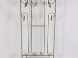 an iron plant stand with a glass door on top of it