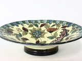 a bowl with a floral design on it on a stand