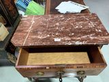 a marble top table with a drawer underneath it