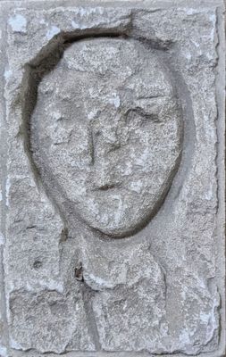 a stone carving of a man ' s face on the side of a building