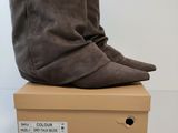 a pair of brown boots sitting on top of a cardboard box