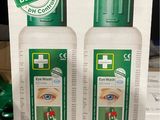 two bottles of eye wash sitting on top of a cardboard box