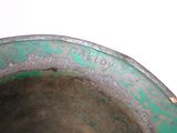 a close up view of a green vase with writing on it