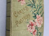 an old book with flowers on it on a table