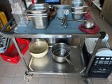 many pots and pans sitting on a metal cart