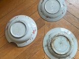 three plates that are sitting on the floor next to each other