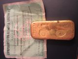 un lingot d'or posé sur une feuille de papier