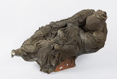 a sculpture of a woman laying on a piece of cloth