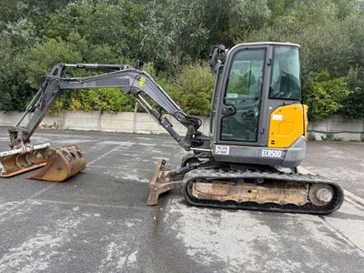 a small excavator that is parked in a parking lot