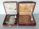 two sets of silverware in a case on a table