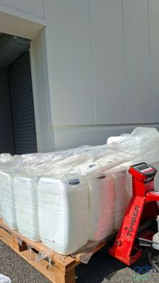 a pallet full of white containers sitting on a pallet
