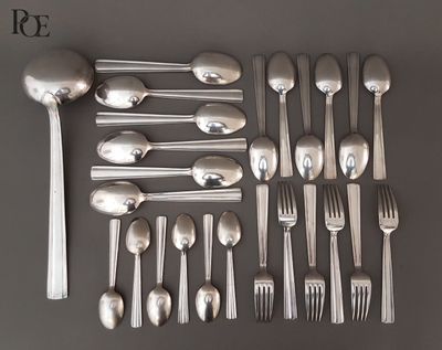 un grand nombre de cuillères et de fourchettes en argent disposées sur une table