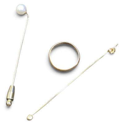 a ring, a pin, and a pair of pins on a white surface
