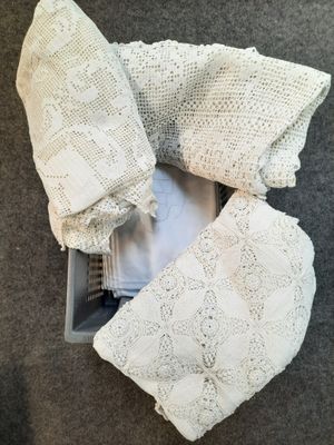 vue de dessus d'un pull blanc au crochet et d'un pantalon dans un bac en plastique
