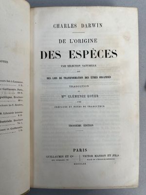 un livre ouvert posé sur une table à côté d'une paire de ciseaux