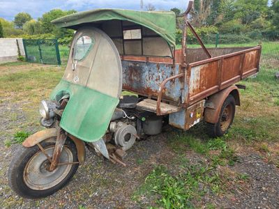 un vieux camion auquel est attelée une moto