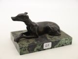 a statue of a dog sitting on a marble base