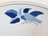 a blue and white plate with a bird on it