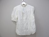 white blouse with a bow on a hanger on a wall