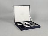 a close up of a box of coins on a white surface