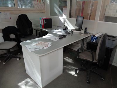 un bureau avec un ordinateur et une chaise dans une pièce
