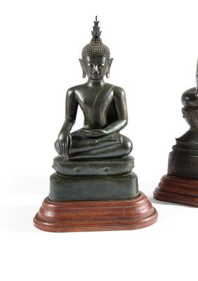 deux statues de bouddhas assis sur un socle en bois