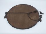 an old wooden plate with a rope around it on a white surface