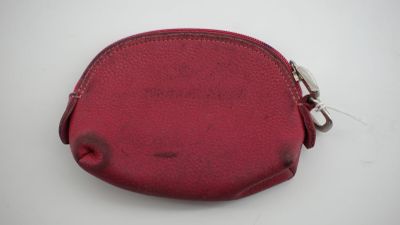 porte-monnaie en cuir rouge sur fond blanc, orné de découpes