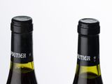 two bottles of wine sitting next to each other on a table