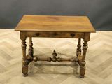 an old wooden table sitting on top of a hard wood floor