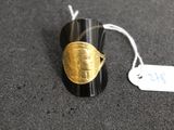une bague noire et dorée ornée d'un motif doré