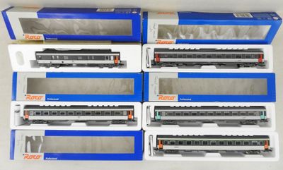 six trains miniatures sont rangés dans des boîtes posées sur une surface blanche